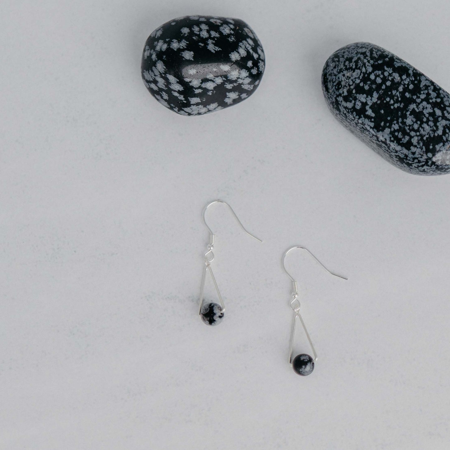 Handgefertigte Montara Ohrringe in Dreiecksform – inspiriert von der Bergform. Dezenter, moderner Edelsteinschmuck mit Schneeflockenobsidian. Einzigartige Begleiter von Moonlight Edelsteine.