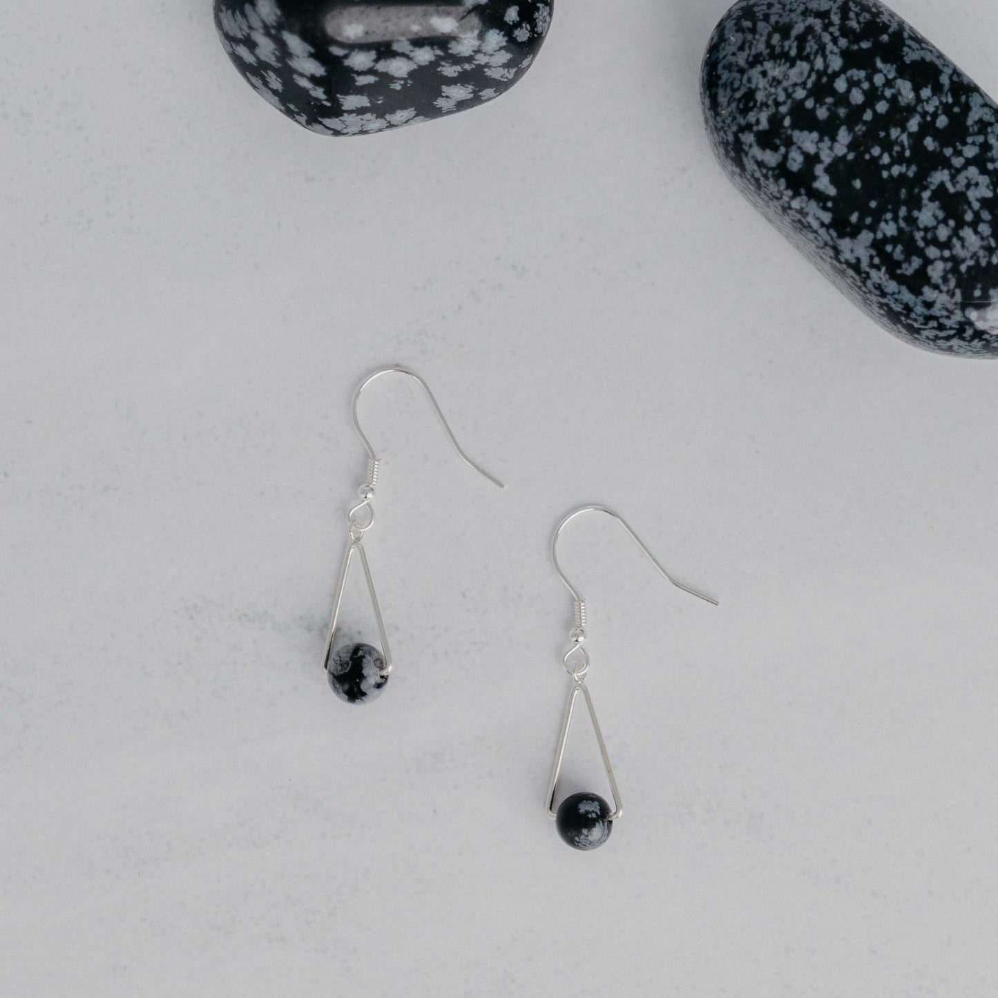 Handgefertigte Montara Ohrringe in Dreiecksform – inspiriert von der Bergform. Dezenter, moderner Edelsteinschmuck mit Schneeflockenobsidian. Einzigartige Begleiter von Moonlight Edelsteine.