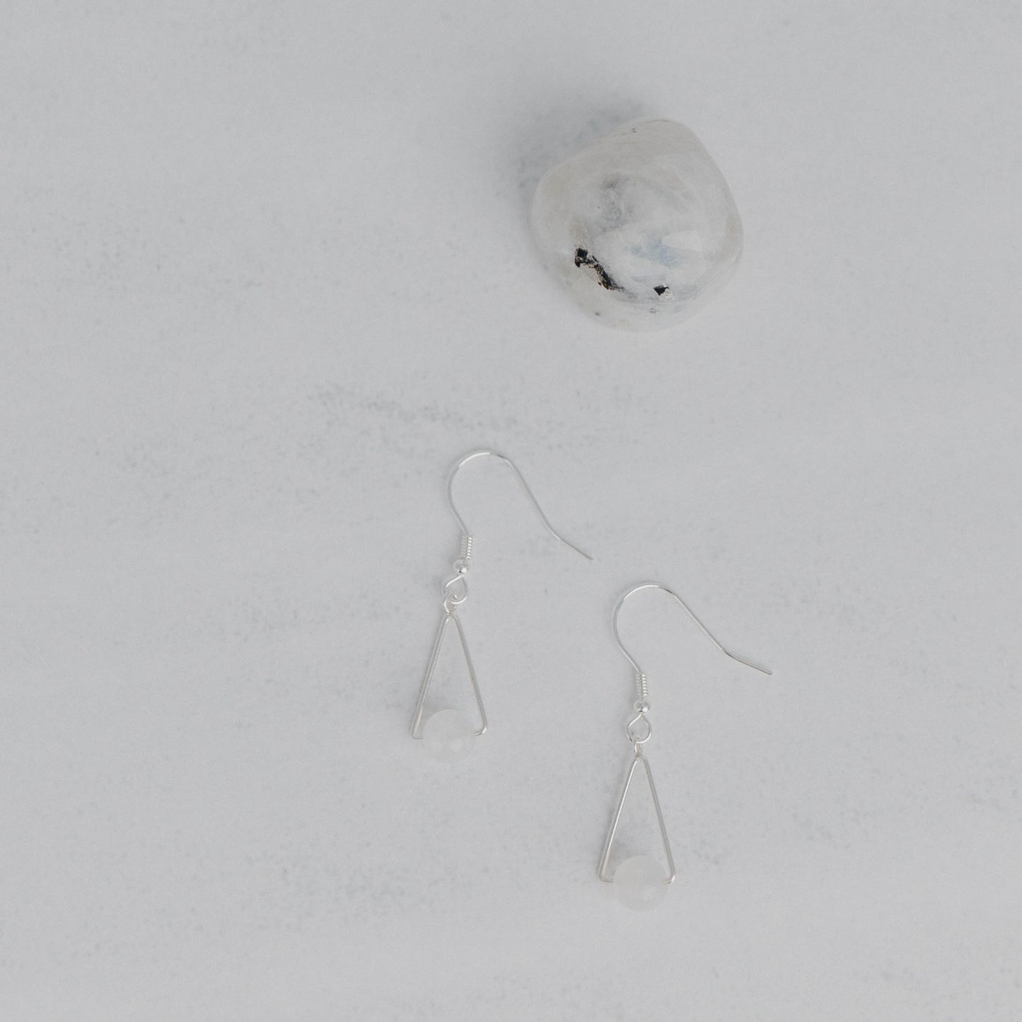 Handgefertigte Montara Ohrringe in Dreiecksform – inspiriert von der Bergform. Dezenter, moderner Edelsteinschmuck mit weisser Mondstein. Einzigartige Begleiter von Moonlight Edelsteine.