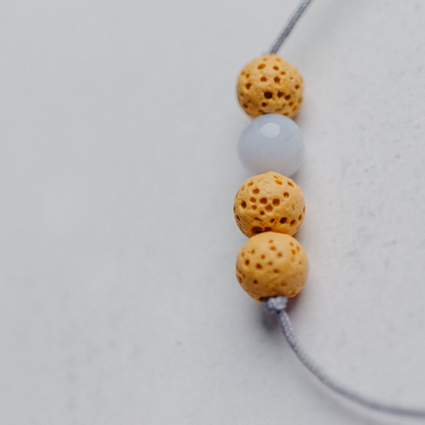 Zartes Diffusor Armband mit 3 Lavaperlen auf Nylonband – stilvoller Aroma-Schmuck für deine ätherischen Öle.