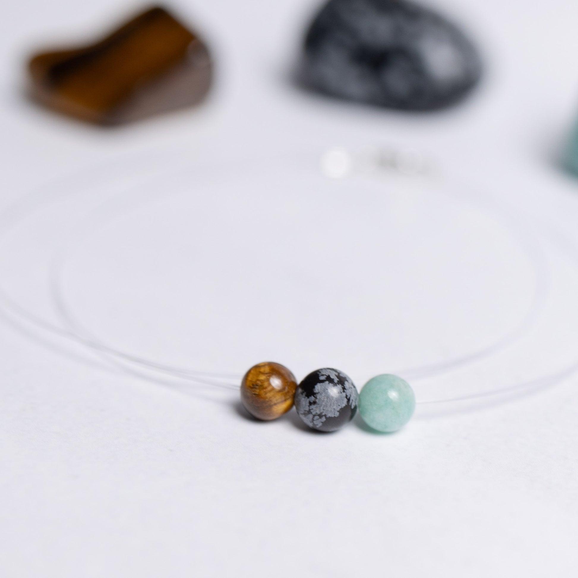 Human Design Kette Generator – Amazonit, Schneeflockenobsidian und Tigerauge auf transparentem Nylonband mit 6mm Perle