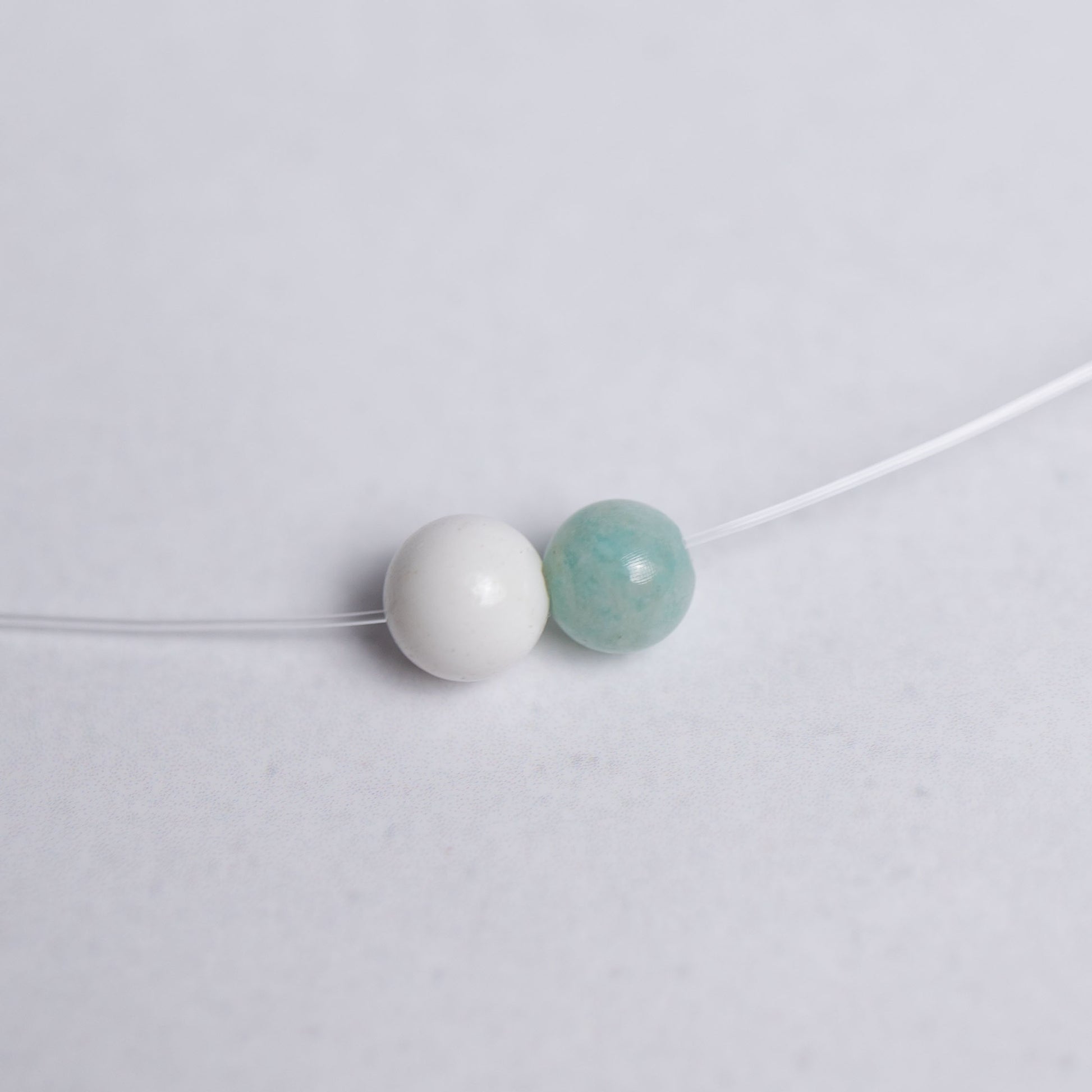 Feine Lebensfreude Kette mit transparentem Nylonband und je einer 6mm Perle aus Amazonit und Magnesit – Schmuck für Balance und gute Energie
