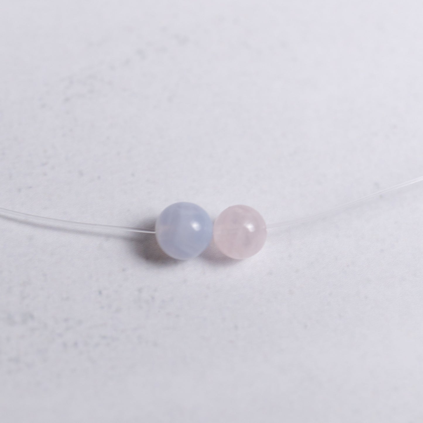 Selbstliebe Kette mit transparentem Nylonband und je einer 6mm Perle aus Rosenquarz und Chalcedon – minimalistischer Energieschmuck