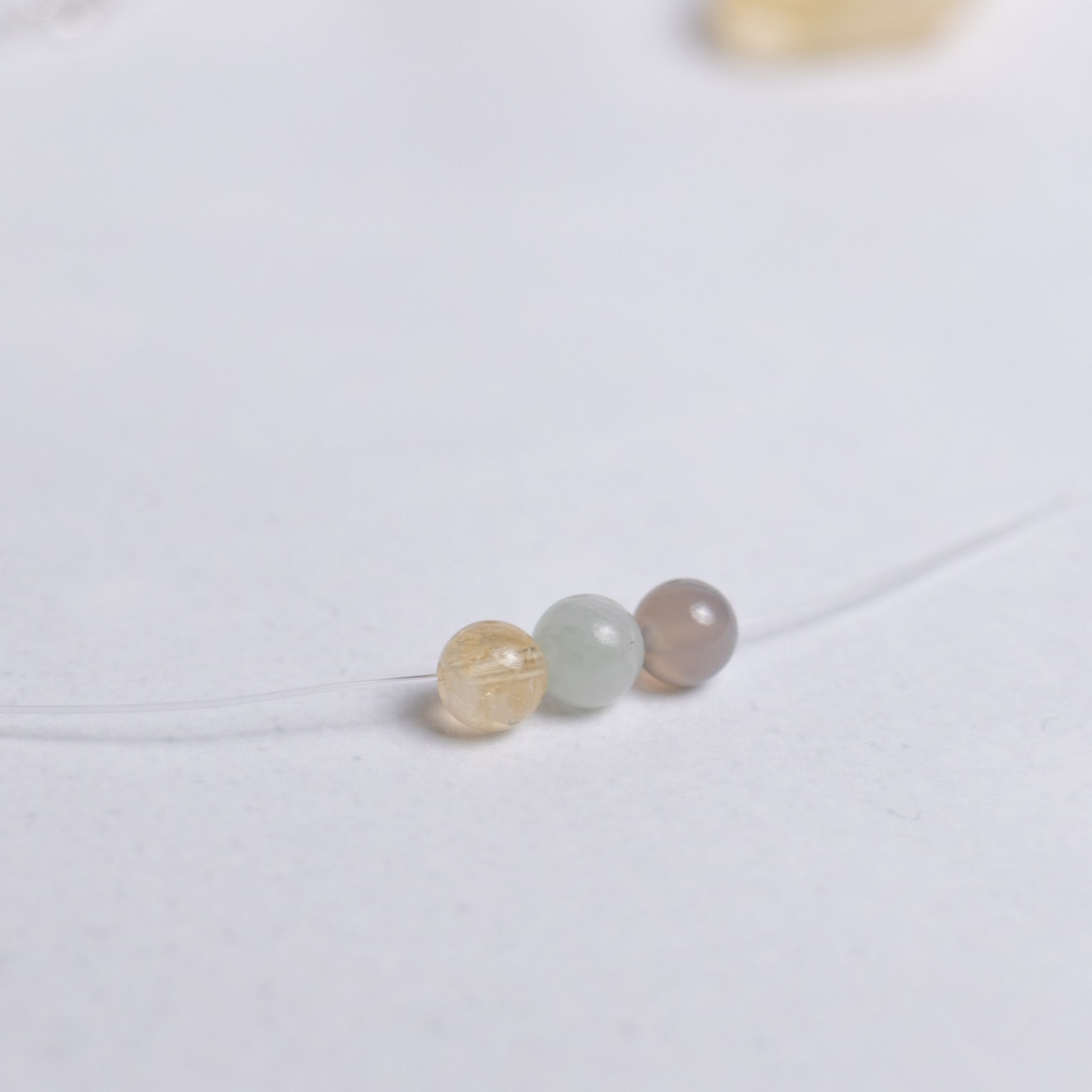 Surf die Welle Kette mit transparentem Nylonband und je einer 6mm Perle aus Achat, Jade und Citrin – stilvoller Begleiter für Energie und Harmonie