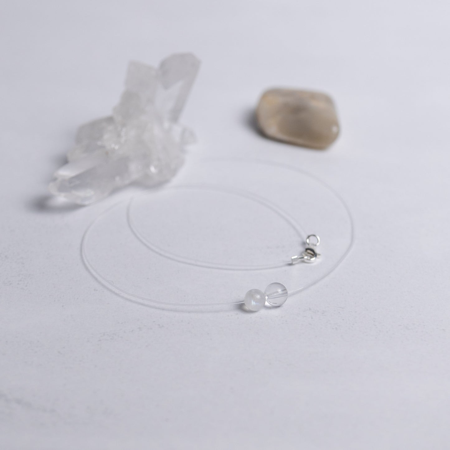 Zurück zu dir Kette mit transparentem Nylonband und je einer 6mm Perle aus Mondstein und Bergkristall – stilvoller Edelsteinschmuck für innere Ruhe und Klarheit