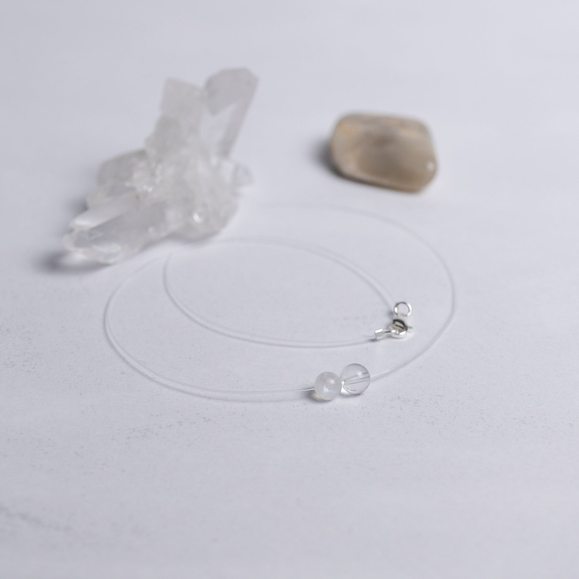 Zurück zu dir Kette mit transparentem Nylonband und je einer 6mm Perle aus Mondstein und Bergkristall – stilvoller Edelsteinschmuck für innere Ruhe und Klarheit