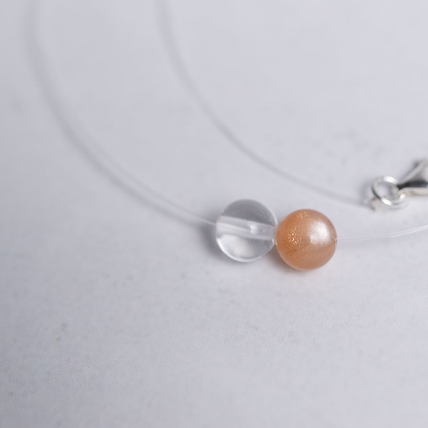 Zurück zu dir Kette mit transparentem Nylonband und je einer 6mm Perle aus Mondstein und Bergkristall – stilvoller Edelsteinschmuck für innere Ruhe und Klarheit