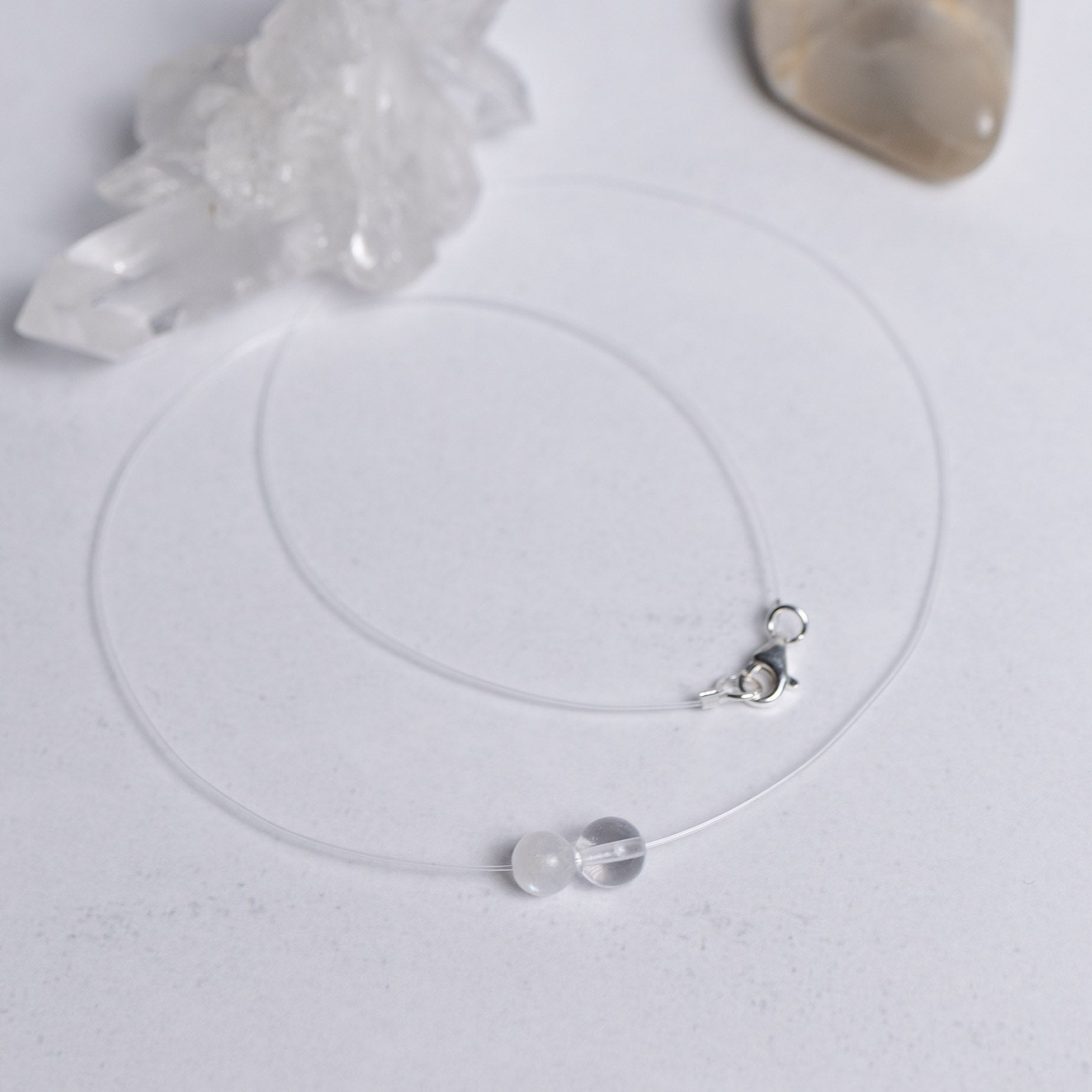 Zurück zu dir Kette mit transparentem Nylonband und je einer 6mm Perle aus Mondstein und Bergkristall – stilvoller Edelsteinschmuck für innere Ruhe und Klarheit